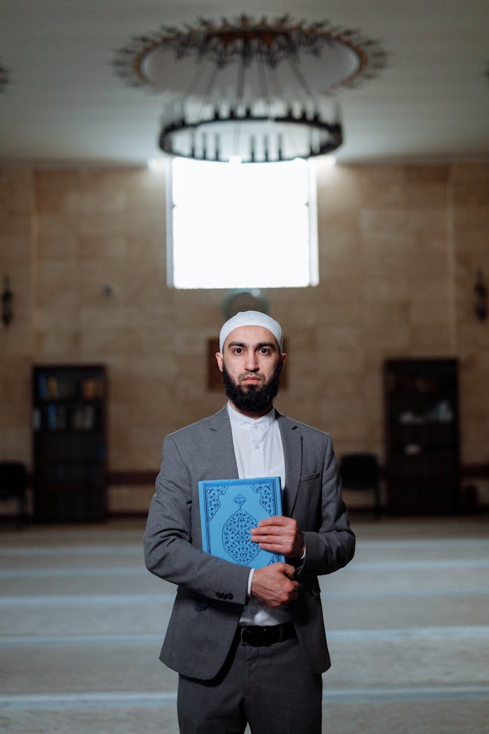 services-02 A Muslim man holding the Quran inside a mosque, symbolizing faith and devotion.